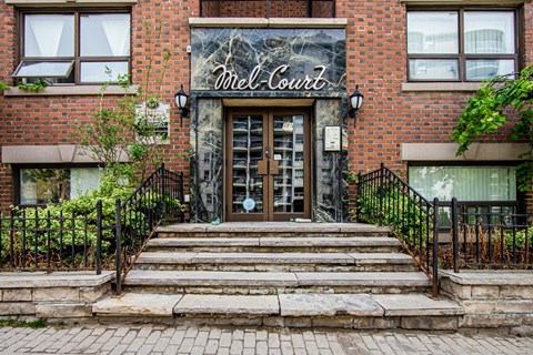 the front of a brick building with stairs and a door